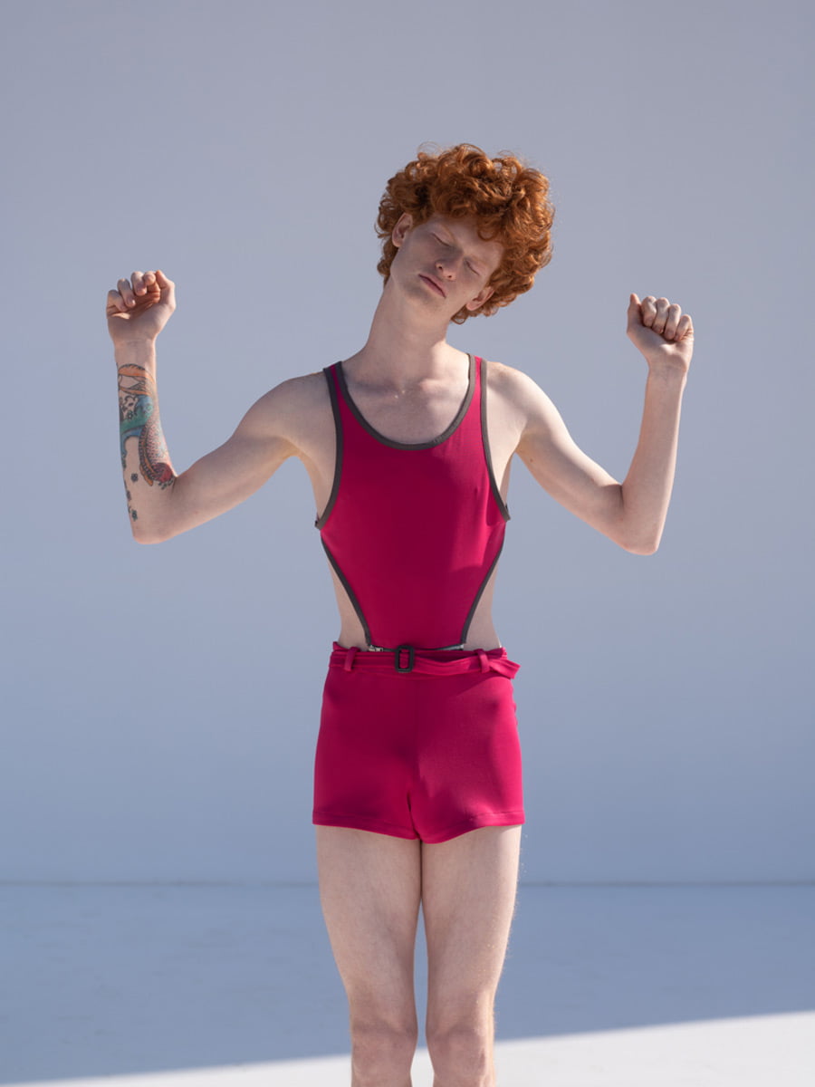 Boy with red hair wearing pink play suit