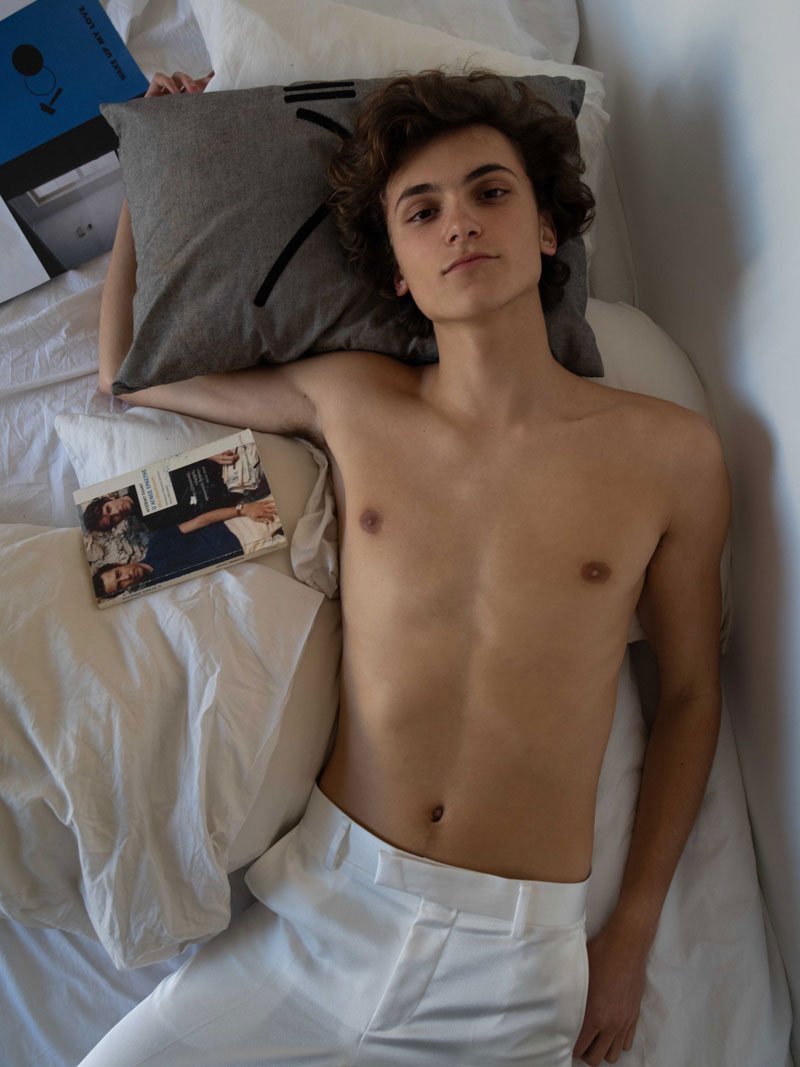 Half naked man laying on a bed