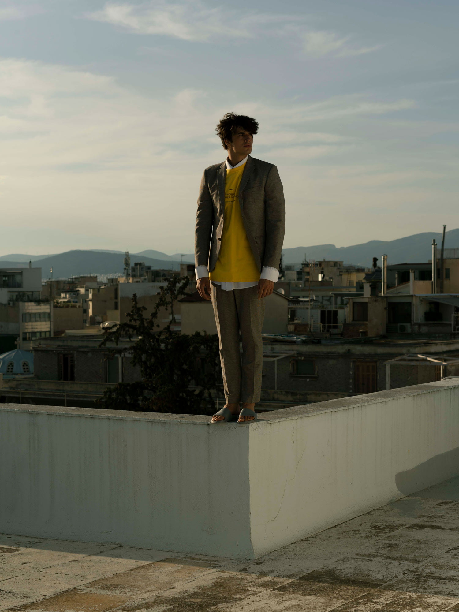 Portrait of a man wearing a suit on the edge of a rooftop