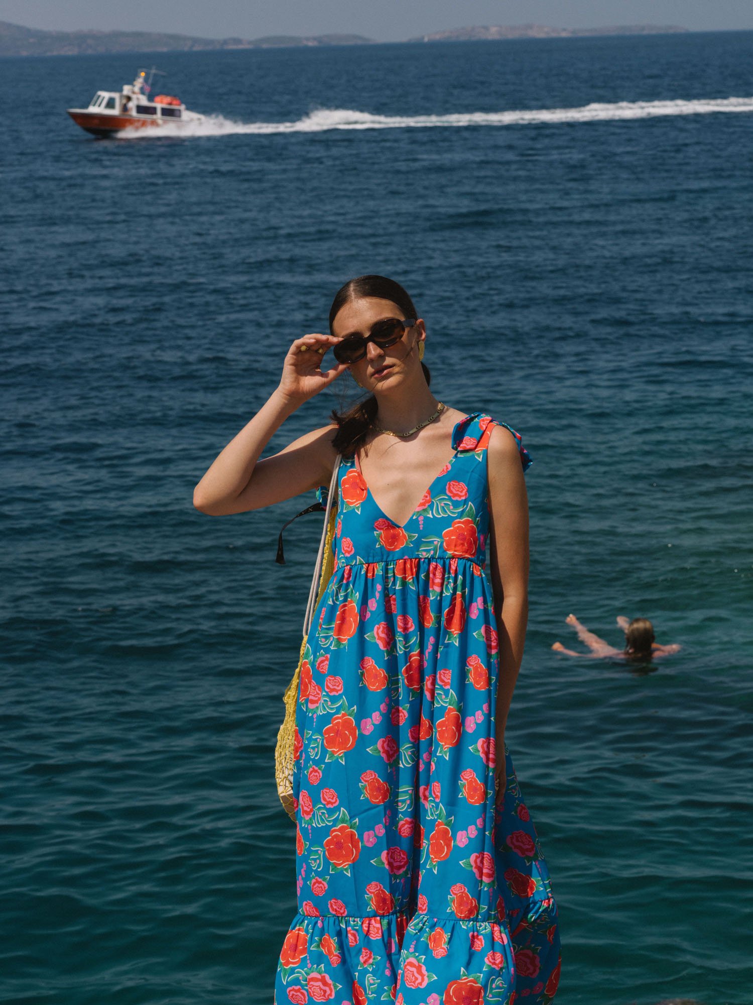 Portrait of a woman wearing an blue dress next to the sea